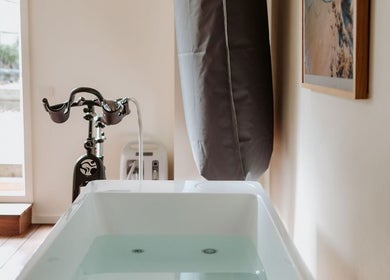 Relaxation area at SHUGENDŌ RECHARGE STUDIO in Cape Paterson, Victoria, AU with tub and exercise bike.