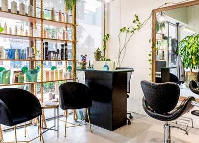 Modern salon interior at Serenity Hair & Co, Surry Hills, New South Wales, AU, showcasing sleek chairs and product displays.