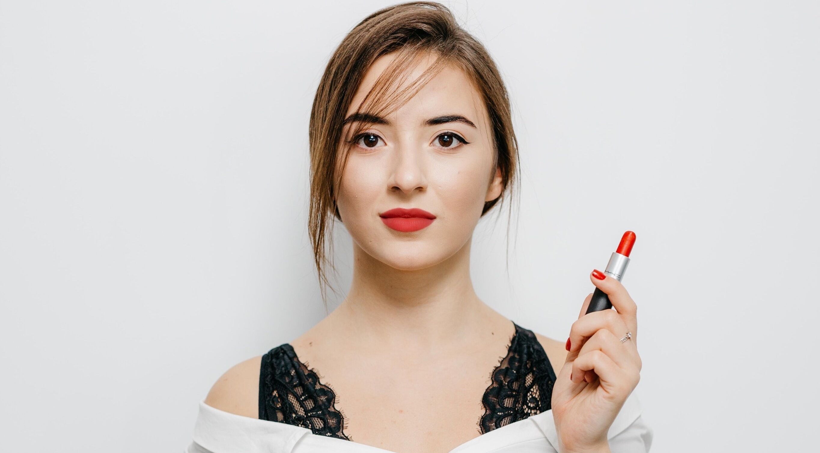 Woman holding red lipstick at Iryna Aksanii Studio, Manchester, England, GB.