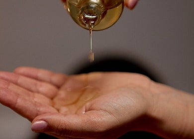 Huile de massage versée dans la main chez Ines SELKA - Massage Bien-être, Mantes-la-jolie, Île-de-france, FR.