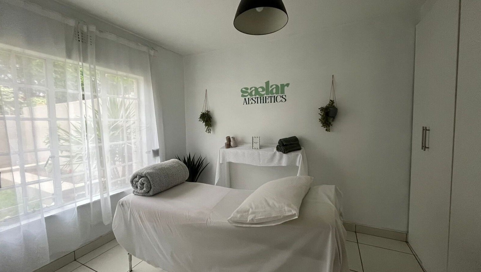 Calming treatment room at Sælar Aesthetics, located in Edenvale, Gauteng, ZA, with natural light and plush bed.