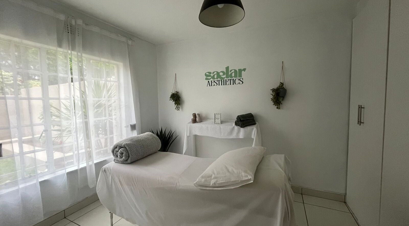 Calming treatment room at Sælar Aesthetics, located in Edenvale, Gauteng, ZA, with natural light and plush bed.