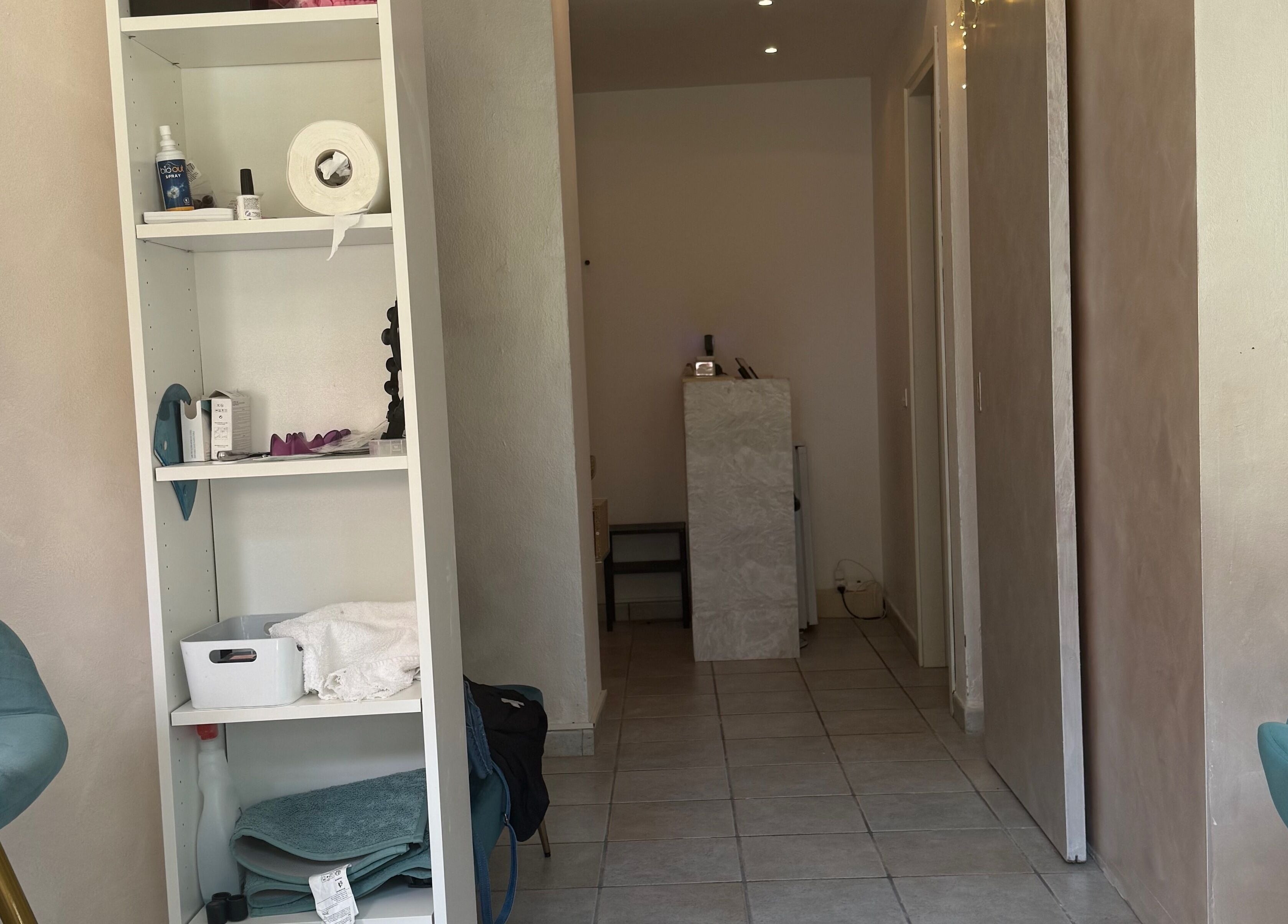 Interno di Daylin Faith Beauty a Vimercate, Lombardia, IT, con scaffale e sedie blu.