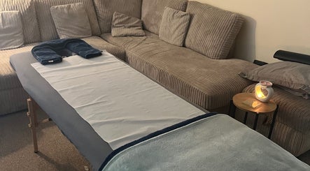Cozy massage table setup at At Ease massage and energy treatments in Stevenage, England, GB, with soft lighting.