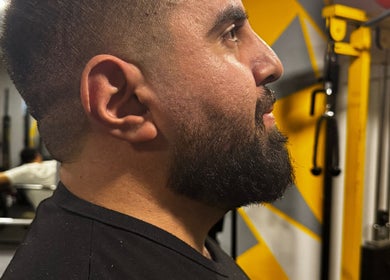Close-up of a bearded man at The Meister Barber, Jabal Lubnan, LB, showcasing expert grooming technique.