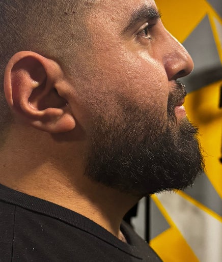 Close-up of a bearded man at The Meister Barber, Jabal Lubnan, LB, showcasing expert grooming technique.