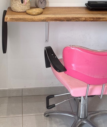 Coin salon moderne à A Bsolu Coiffure, Serrières-de-briord, Auvergne-rhône-alpes, FR avec fauteuil rose.