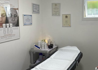 Cozy treatment room at CC Hair Studio, Oxford, England, GB with skincare products and certificates displayed.