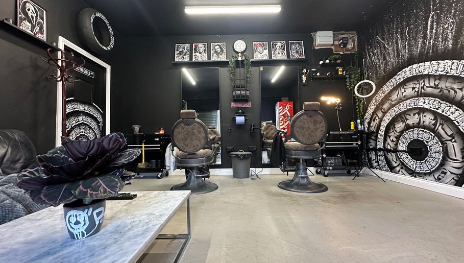 Trendy interior of Rejects Barbers in Boldon Colliery, England, GB with stylish chairs and artwork.