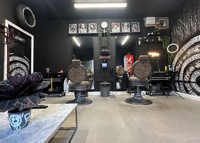 Trendy interior of Rejects Barbers in Boldon Colliery, England, GB with stylish chairs and artwork.