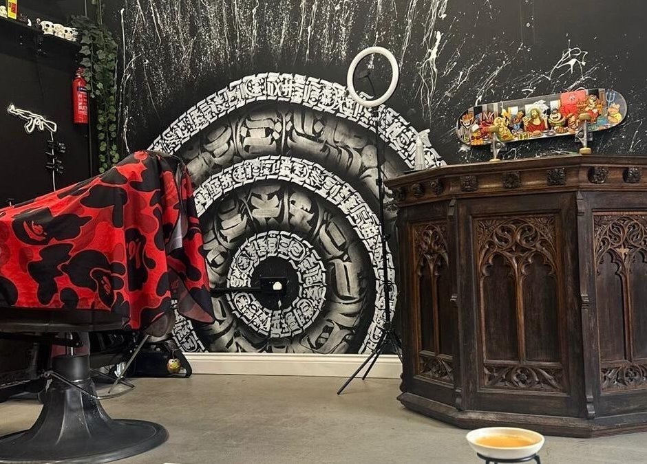 Interior of Rejects Barbers in Boldon Colliery, England with a unique wall mural and ornate wooden furniture.