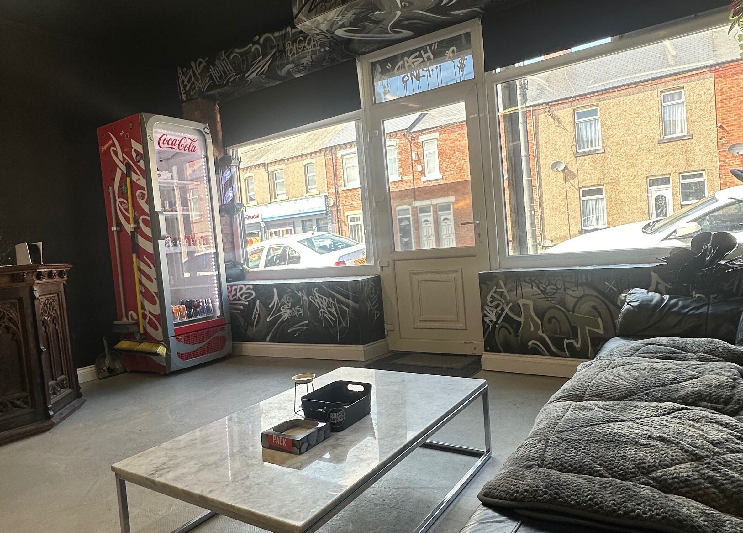 Cozy seating area at Rejects Barbers, Boldon Colliery, England, GB with modern decor and street view.
