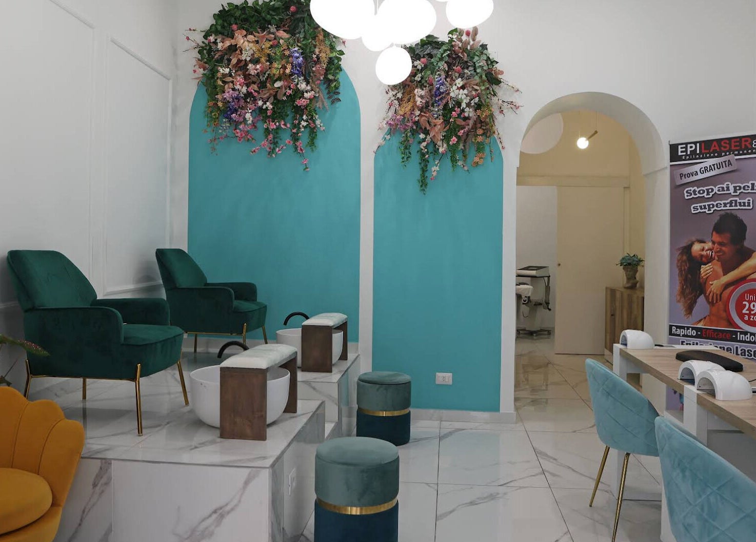Interno di Frida Nails a Roma, Lazio, con sedie verdi e pareti turchesi decorate con fiori.