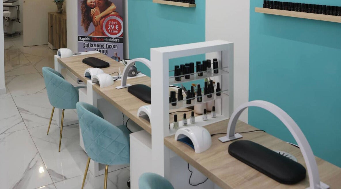 Postazione manicure moderna da Frida Nails a Roma, Lazio, IT, con sedie blu e smalti in esposizione.