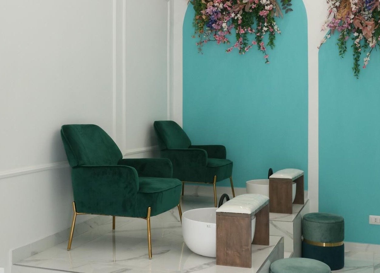 Spazio pedicure elegante presso Frida Nails a Roma, Lazio, IT con poltrone verdi e decorazioni floreali.