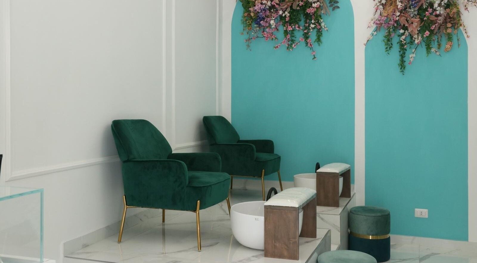 Spazio pedicure elegante presso Frida Nails a Roma, Lazio, IT con poltrone verdi e decorazioni floreali.