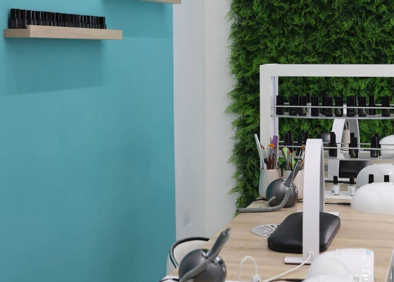 Interni di Frida Nails a Roma, Lazio, IT con postazione elegante e parete verde.