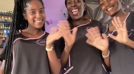Smiling team at Chan's Unique Hair Studio, Kingstown, St. George, VC, waving in a welcoming gesture.