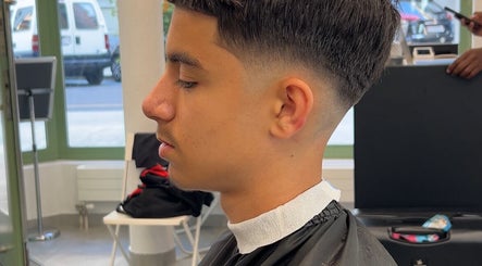 Coiffure moderne à Sniperkut, Genève, avec un dégradé soigné et détail de coupe.