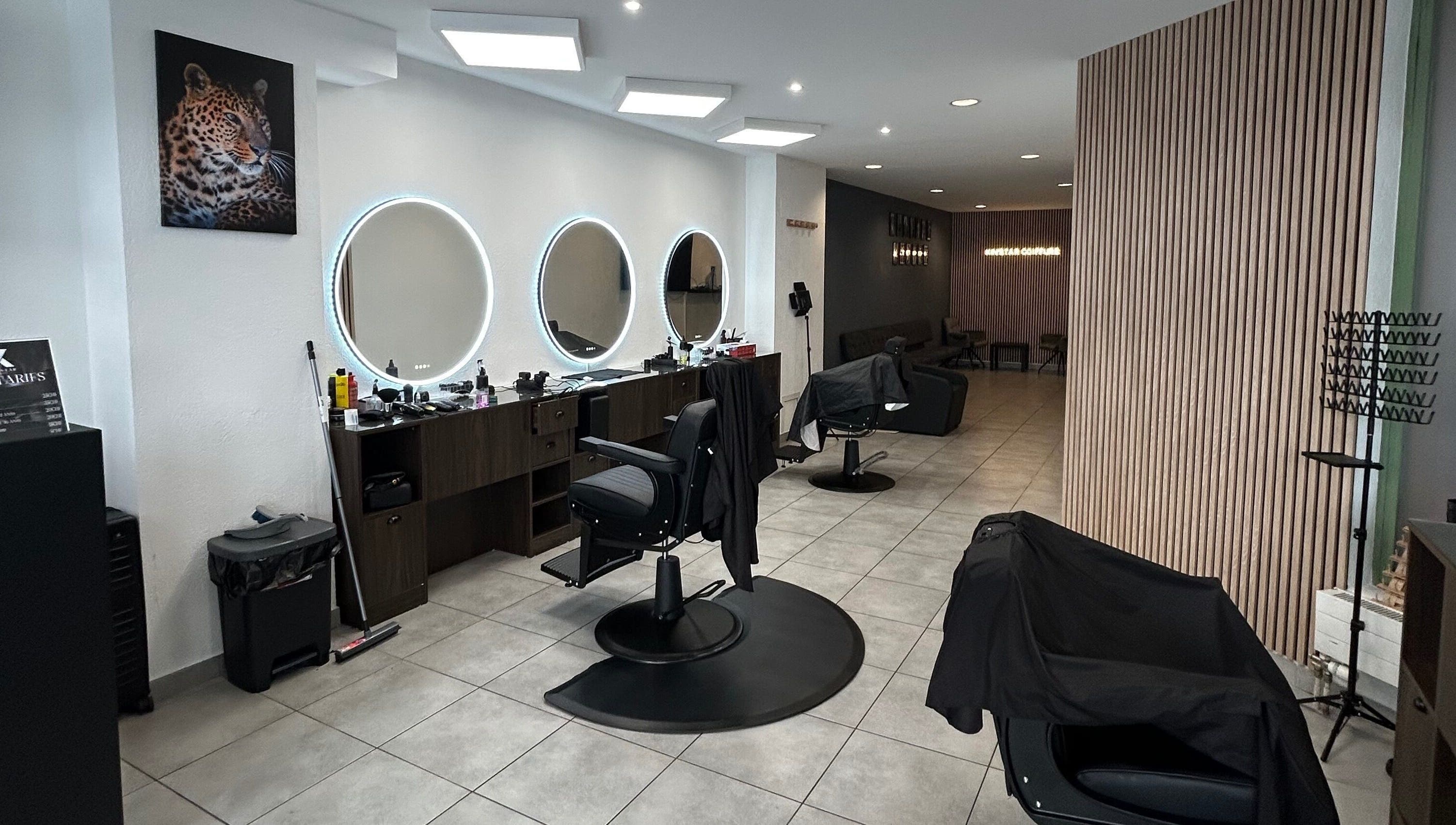 Intérieur chic du salon Kinstar à Genève, Genève, CH avec miroirs circulaires et fauteuils modernes.