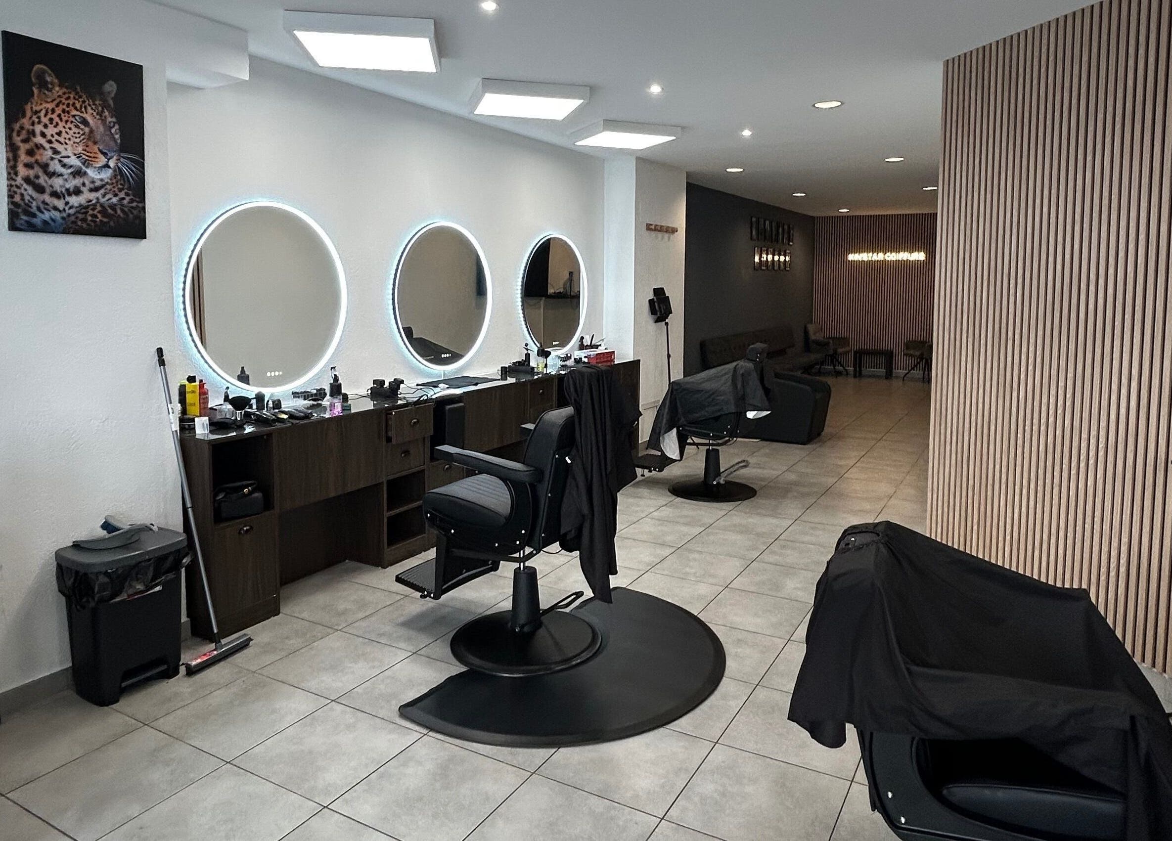 Intérieur chic du salon Kinstar à Genève, Genève, CH avec miroirs circulaires et fauteuils modernes.