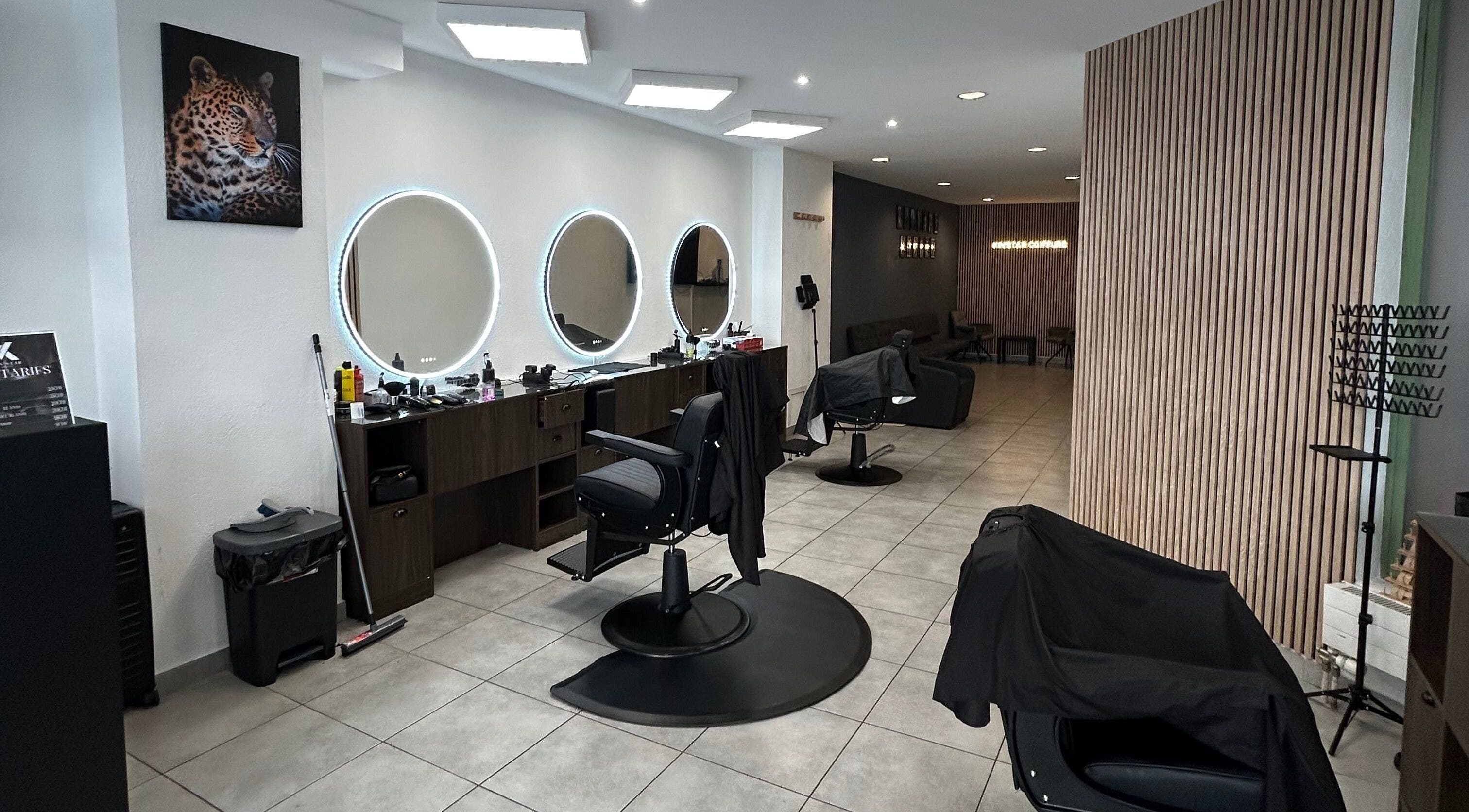 Intérieur chic du salon Kinstar à Genève, Genève, CH avec miroirs circulaires et fauteuils modernes.