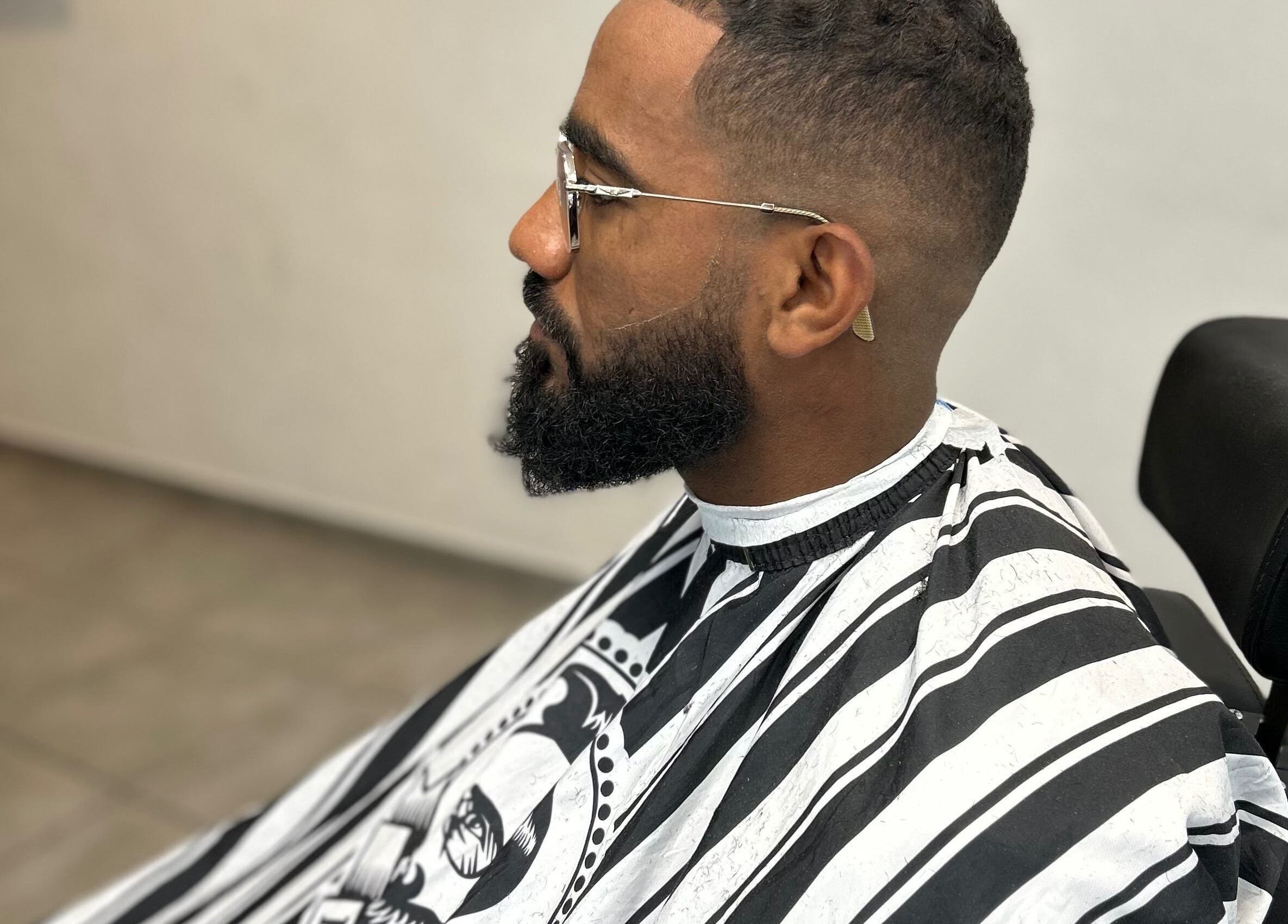 Client chez Kinstar à Genève, Genève, CH, recevant une coupe élégante dans un fauteuil de barbier moderne.