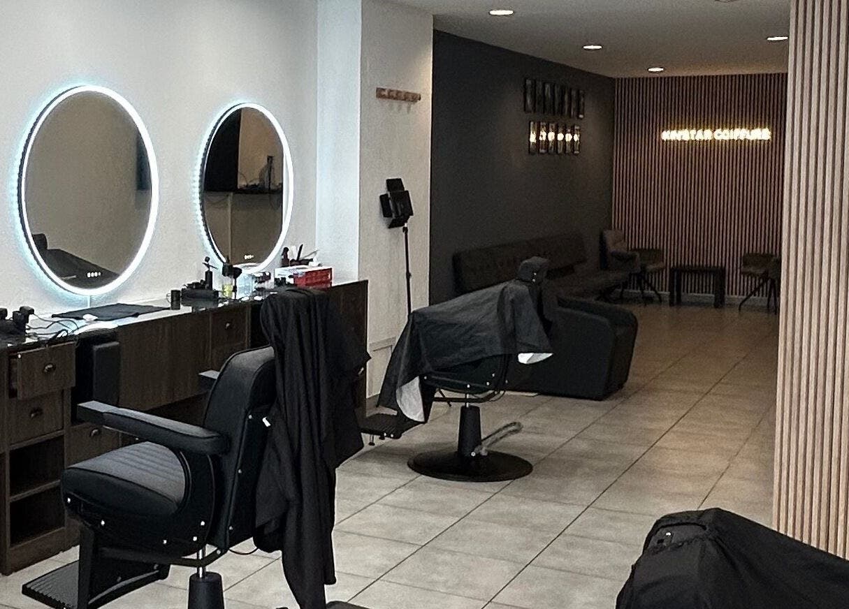 Salon moderne chez Kin'star à Genève, Genève, CH, avec des miroirs lumineux et des sièges élégants.