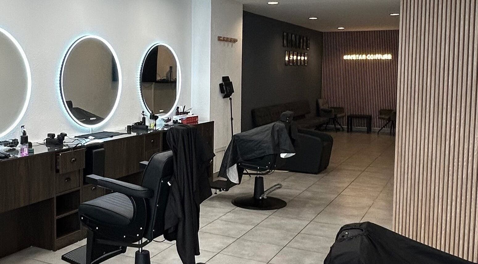 Salon moderne chez Kin'star à Genève, Genève, CH, avec des miroirs lumineux et des sièges élégants.