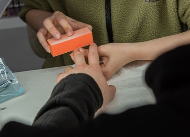 Nail technician buffing nails at Pick Your Color Nail Salon, Chicago, IL, US for perfect finish.