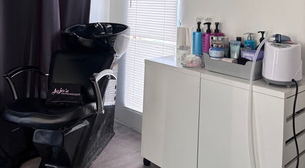 Styling station at JoJo's Hair Spa, Corringham, England, GB, featuring premium hair products and a sleek chair.