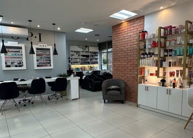 Interior moderno de The Factory Afro Curly Santo Domingo en Santo Domingo, Heredia, CR, mostrando estaciones de trabajo y productos.
