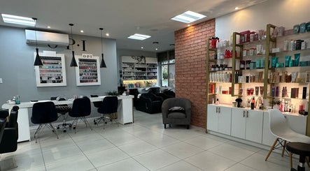 Interior moderno de The Factory Afro Curly Santo Domingo en Santo Domingo, Heredia, CR, mostrando estaciones de trabajo y productos.