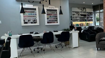 Interior de The Factory Afro Curly Santo Domingo con mesas de manicura y sillas modernas en Santo Domingo, Heredia, CR.