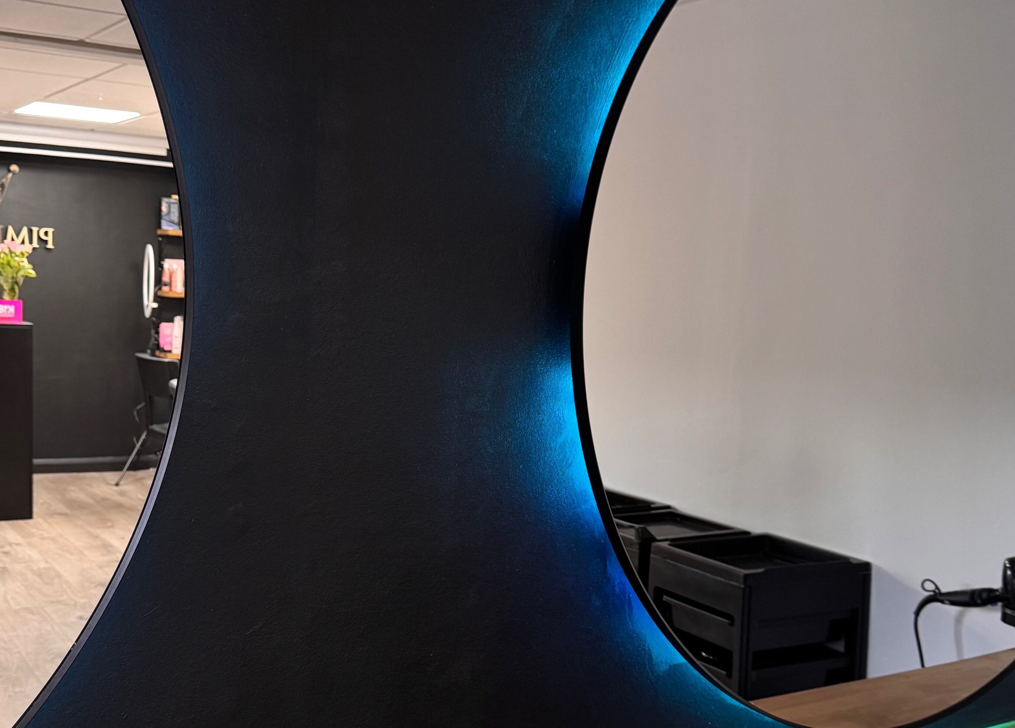 Modern salon mirror at Pimp My Hair, Aberdeen, Scotland, GB, showcasing sleek interior design.