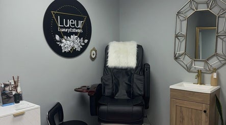 Luxurious treatment chair at Lueur Luxury Esthetics in Naicam, Saskatchewan, CA, alongside stylish decor.