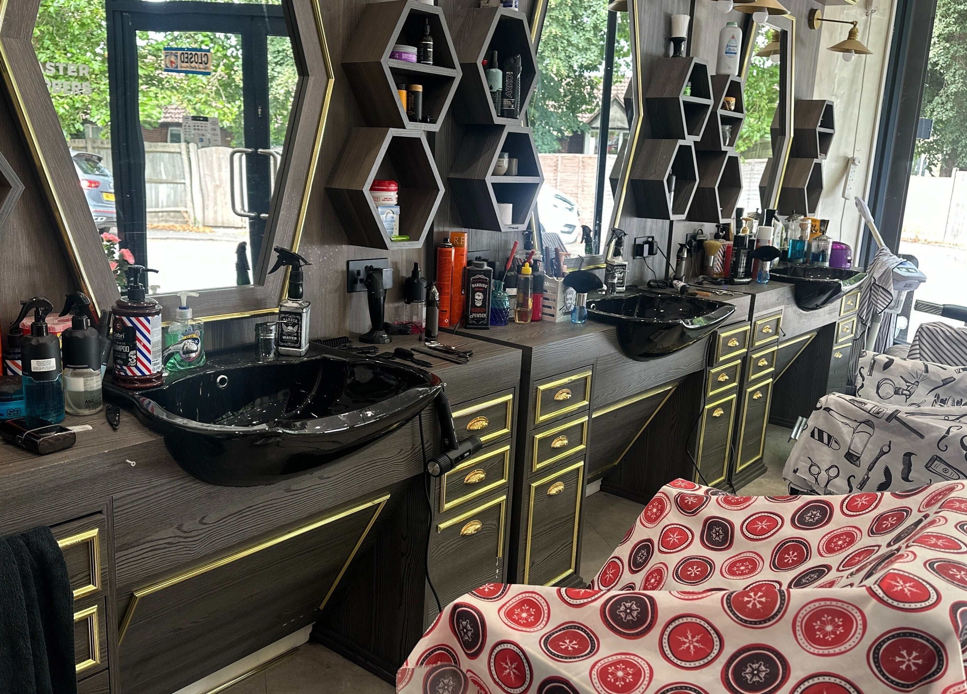 Elegant barbershop interior at Master Barbers, Maidenhead, England, GB with sleek black sinks and artistic mirrors.