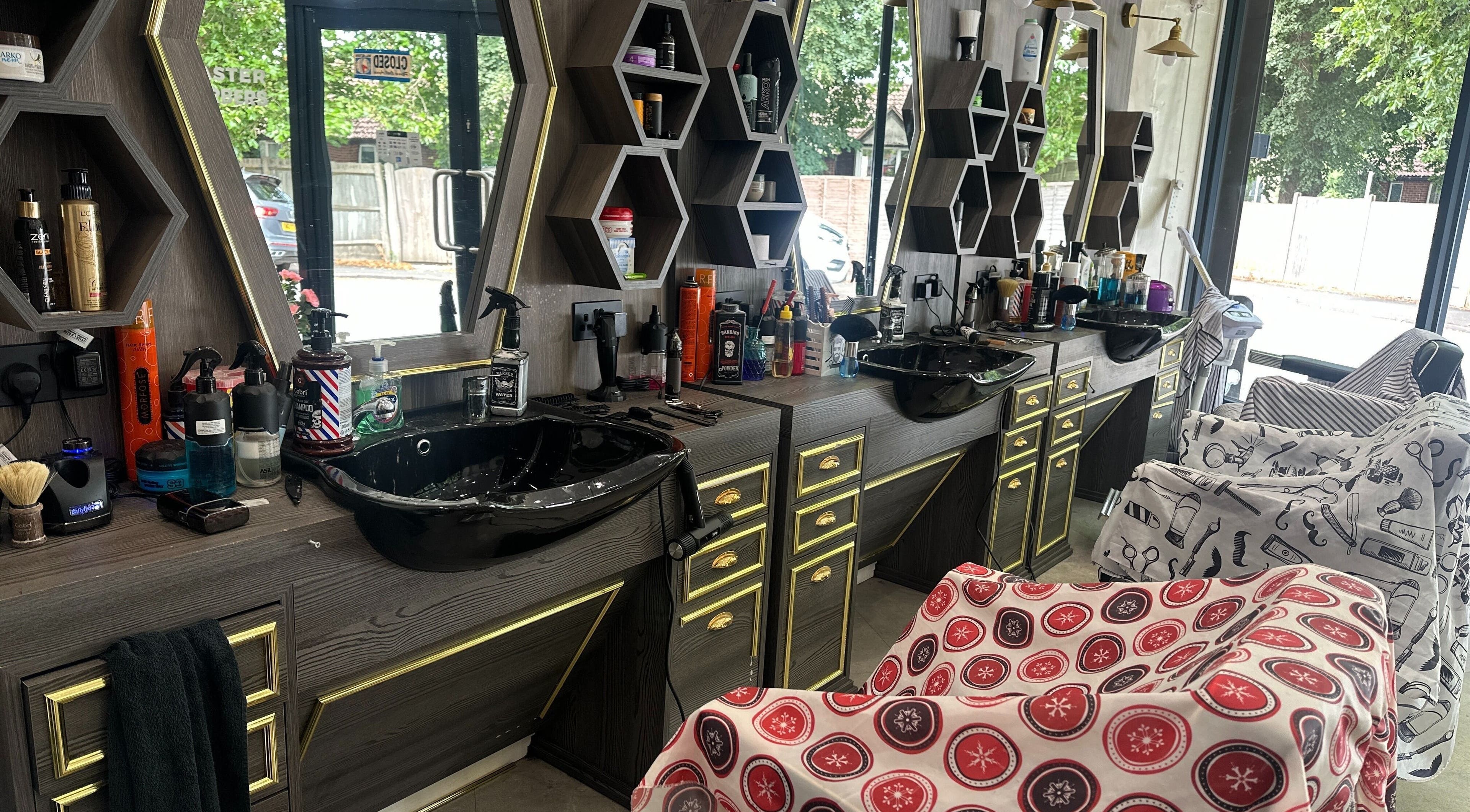 Elegant barbershop interior at Master Barbers, Maidenhead, England, GB with sleek black sinks and artistic mirrors.