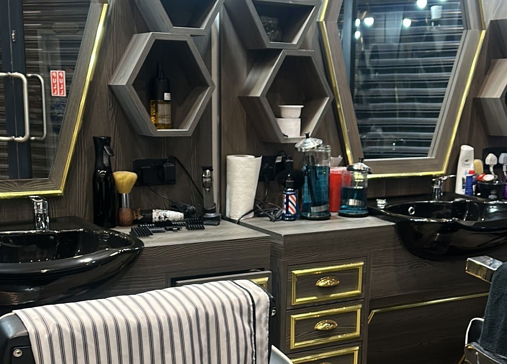Luxurious barber station at Master Barbers, Maidenhead, England, GB with modern hexagonal shelves.
