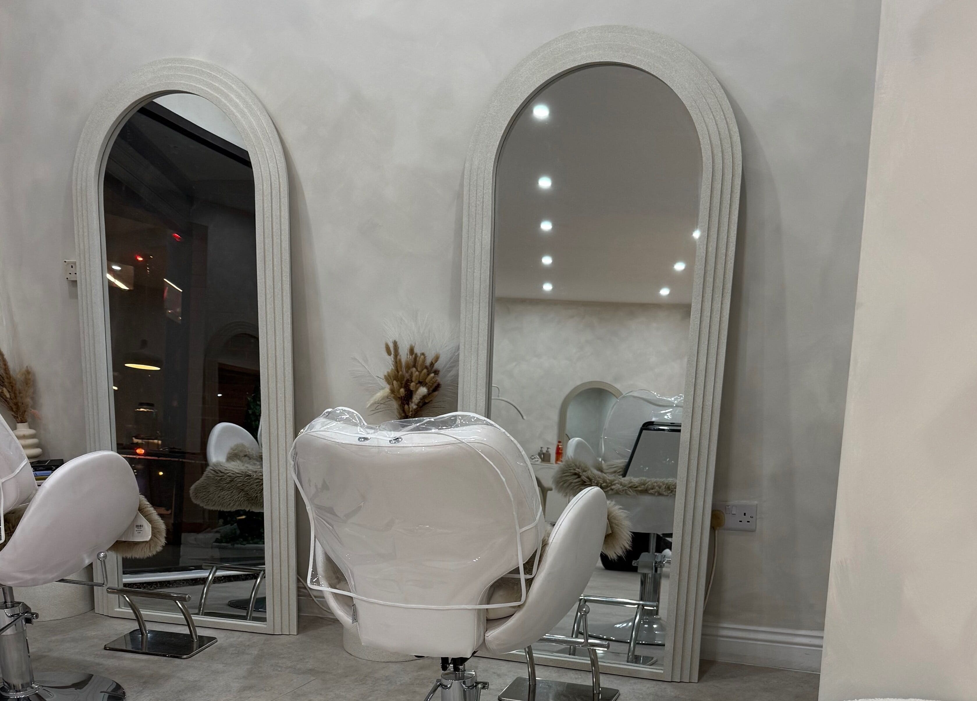 Elegant salon with mirrors and white chairs at Louise Butler Beauty in Kidsgrove, England, GB.