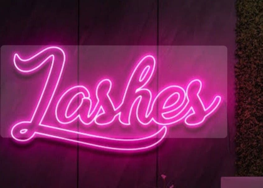 Neon 'Lashes' sign at Lashedbypookie, Harare, Harare Province, ZW, enhancing beauty atmosphere.