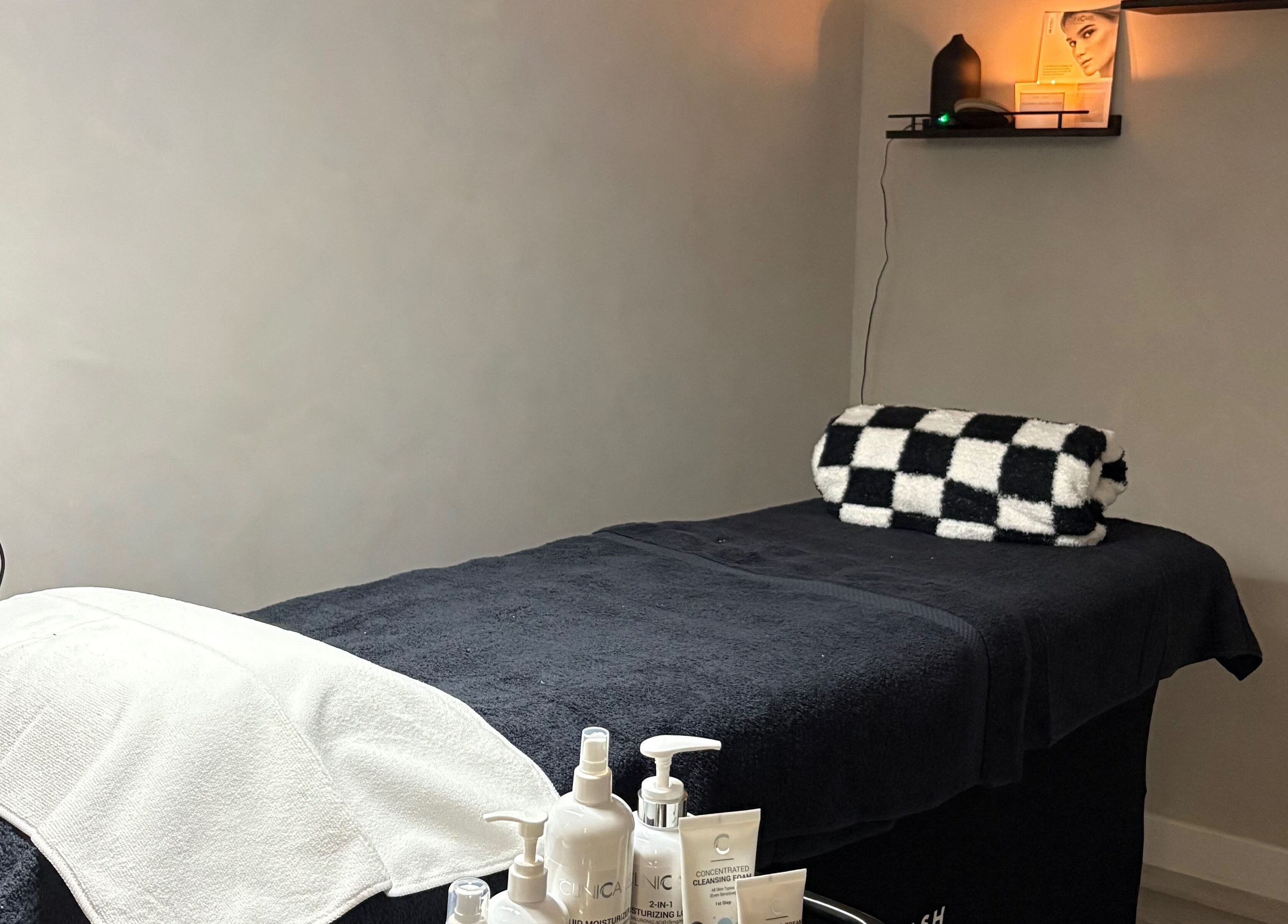 Relaxing treatment room at The SKN Edit, Winsford, England, GB with a comfortable massage table and products.