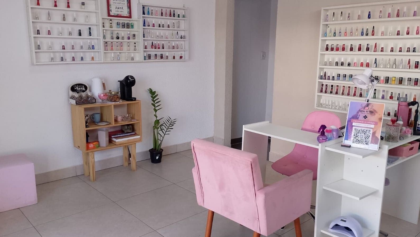 Interior moderno do Talidelpuponails em São Paulo, com poltronas rosas e esmaltes organizados.