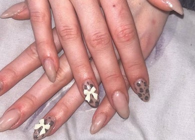 Stylish nail art with leopard print and bow design at Jas’ Nail Lounge in Malvern, England, GB.