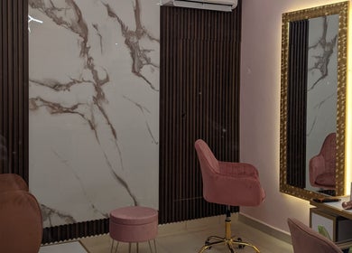 Sala elegante de MF Beauty Salon en Culiacán Rosales, Sinaloa, MX, con silla rosada y espejo iluminado.