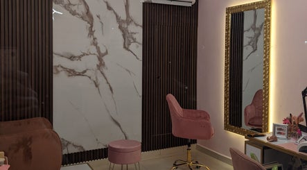 Sala elegante de MF Beauty Salon en Culiacán Rosales, Sinaloa, MX, con silla rosada y espejo iluminado.