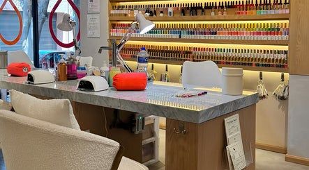 Mesa de manicura en The Nail Shop - The Brow + Lashes Bar, Ciudad De México, con esmaltes de uñas.