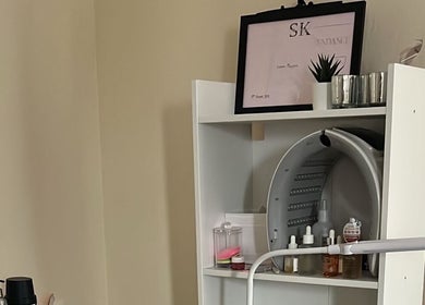NueElleMasion treatment room in London, England, GB, featuring organized beauty products on a sleek shelf.