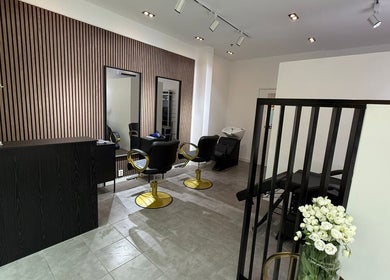 Stijlvol ingerichte salonruimte bij Angelsskin, Rotterdam, Zuid-Holland, NL, met moderne stoelen en spiegelwand.