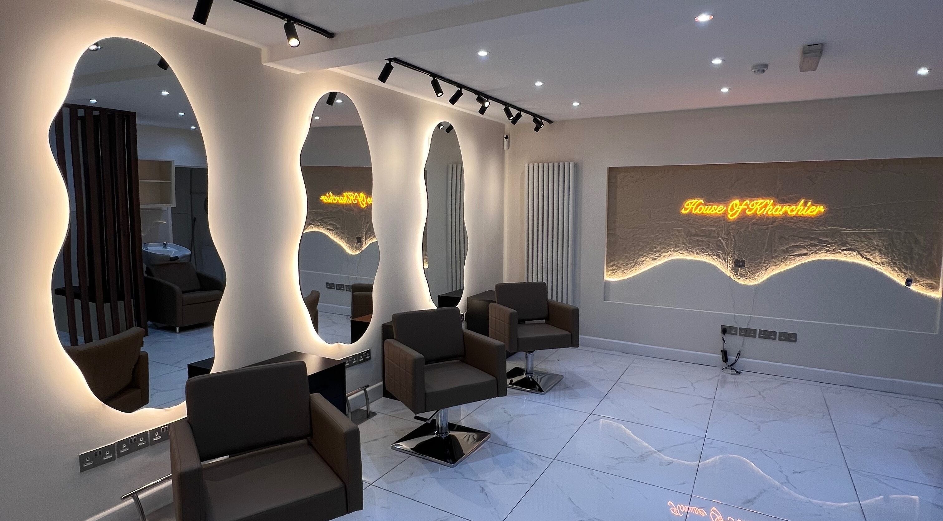 Chic interior of House Of Kharchier Beauty Salon in Birmingham, England, GB with modern lighting and seating.